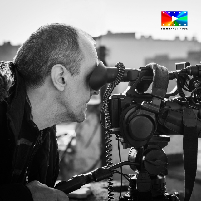 Kameramann schaut durch den Sucher einer professionellen Filmkamera bei Außenaufnahmen. Kameramann schaut durch den Sucher einer professionellen Filmkamera bei Außenaufnahmen.