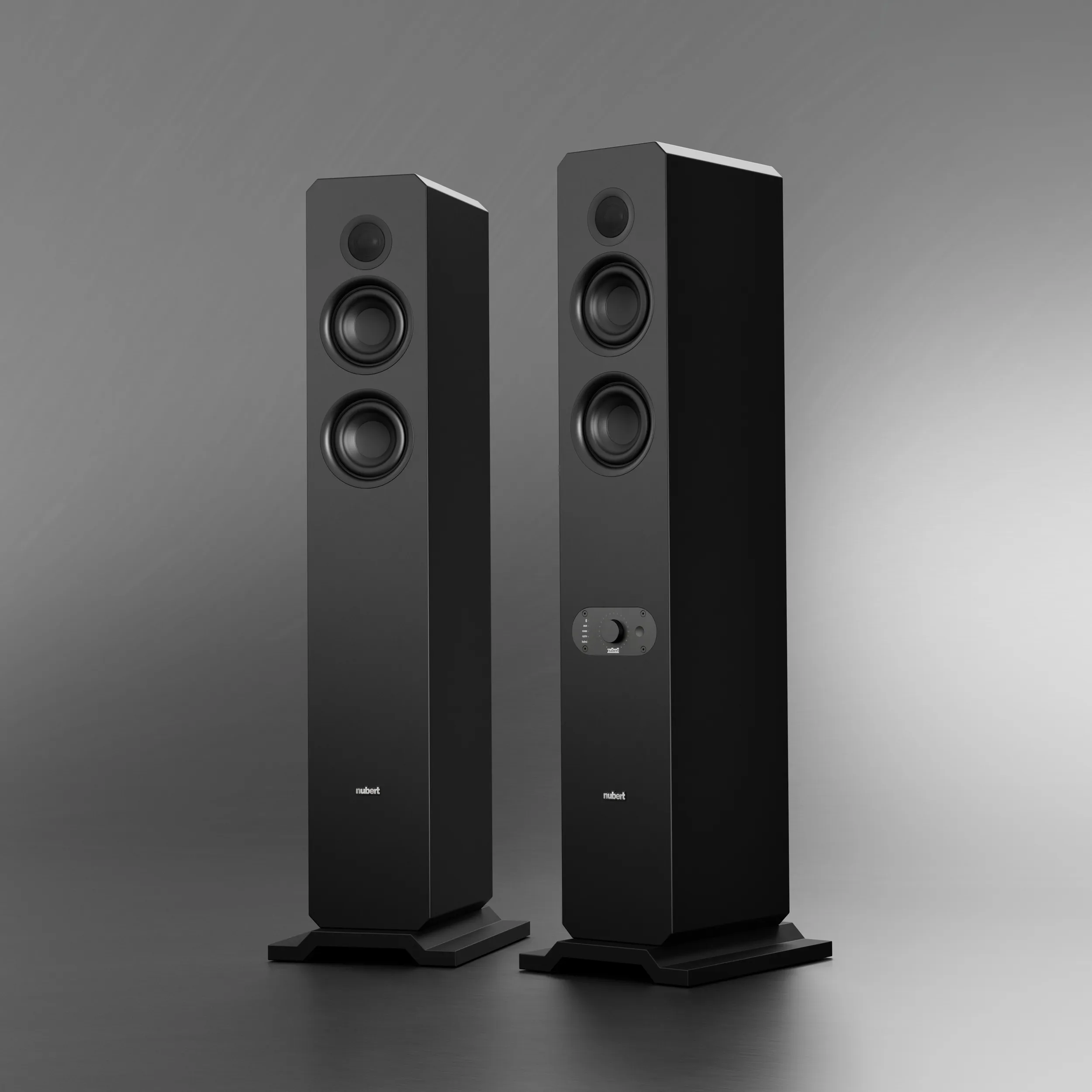 nuJubilee 50 black mood Two black nuJubilees floorstanding speakers against a grey background